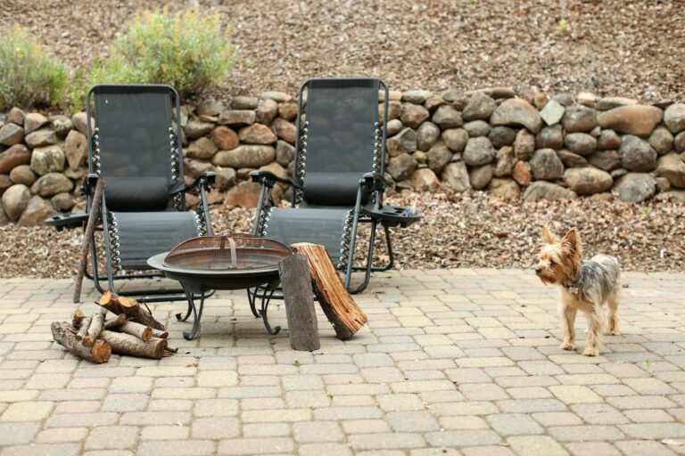 Backyard paver patio with a fire pit, seating and a stone retaining wall